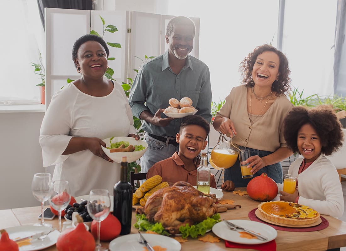 Insurance Solutions - Cheerful Family Celebrating Thanksgiving Near Food at Home